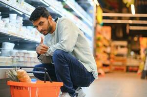 portrait de Indien Masculin dans épicerie avec positif attitude photo