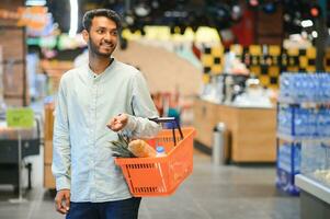 portrait de Indien Masculin dans épicerie avec positif attitude photo