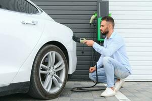 une homme des charges un électrique voiture photo