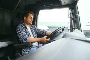 une Jeune Indien Masculin un camion chauffeur est assis derrière le roue photo