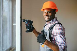 Beau Jeune africain américain homme installation baie fenêtre dans Nouveau maison construction site photo