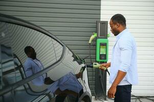 africain américain homme mise en charge le sien électrique auto. photo