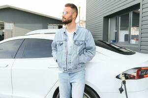 une homme des charges un électrique voiture photo