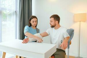 magnifique Jeune médecin en mettant une bandage sur une Masculin les patients bras après nettoyage une blessure dans une hôpital photo