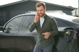 homme mise en charge électrique voiture par le maison photo