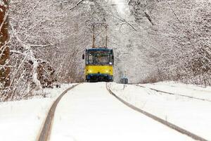 un vieux tramway se déplaçant dans une forêt d'hiver photo