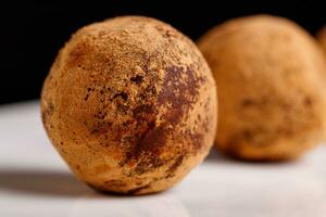 magnifique bonbons truffe sur une blanc assiette sur une noir Contexte photo