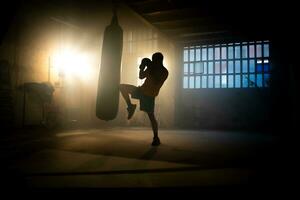 kickboxing ou martial les arts combattant les coups perforation sac avec le genou dans le salle de sport. photo