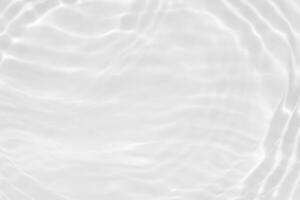 blanc l'eau avec ondulations sur le surface. défocalisation flou transparent blanc coloré clair calme l'eau surface texture avec éclaboussures et bulles. l'eau. photo