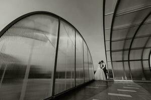 le la mariée et jeune marié contre le Contexte de le ciel. Royal mariage concept. le homme embrasse le la mariée entre grand arcs. tendresse et calme. photo