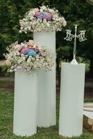 mariage la cérémonie dans le jardin. une luxueux mariage cérémonie. romantique mariage cérémonie. le des stands sont décoré avec coloré fleurs. photo