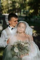 mariage des moments, romance, Jeune couple, la mariée et jeune marié embrasser en dessous de voile dans soleil. bonheur, une baiser, tendresse, sensualité. une Jeune couple photo