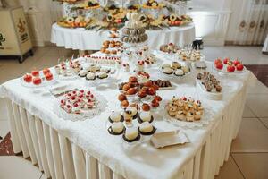 bonbons bar. table avec bonbons, des sucreries, dessert. Gâteaux et baies dans le bonbons bar. bonbons bar avec délicieux mini Gâteaux, sélectif concentrer photo