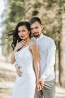 Jeune content couple dans l'amour étreindre souriant et ayant amusement dans le montagnes. haute qualité photo. une fille dans une magnifique blanc robe. portrait photo