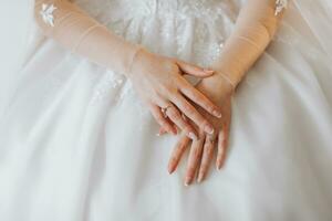 le la mariée dans une blanc mariage robe. content magnifique Jeune femme dans blanc traditionnel mariage robe. de la mariée mains fermer photo