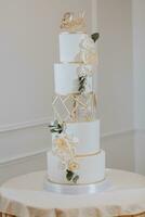 à cinq niveaux mariage gâteau dans blanc couleurs décoré avec fleurs, des roses et or photo