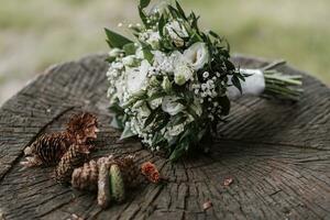 mariage bouquet de blanc fleurs sur une en bois supporter sur une épicéa litière autour beaucoup cônes magnifique texture photo