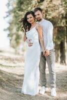 Jeune content couple dans l'amour étreindre souriant et ayant amusement dans le montagnes. haute qualité photo. une fille dans une magnifique blanc robe. portrait photo