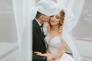 jeune marié et la mariée dans le forêt. l'automne mariage dans le forêt. content mariage, aimant couple soumissionner touche en dessous de le voile. élégant et belle. Princesse robe avec une longue train. photo