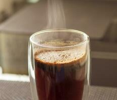 coup de le chaud l'eau versé dans le transparent tasse à brasser le café. boisson photo