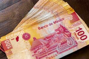 playa del Carmen quintana roo Mexique 2021 empiler de billets de banque 100 mexicain pesos sur une en bois tableau. photo