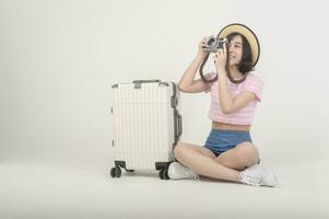 jeune femme touristique asiatique heureuse sur fond blanc concept de studio, de voyage et de vacances. photo