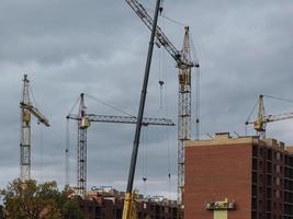 grues jaunes sur le fond des bâtiments en construction photo