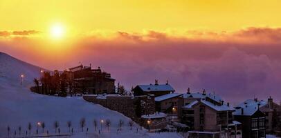magnifique le coucher du soleil dans neigeux montagneux village photo