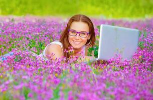 jolie femme avec portable sur floral champ photo