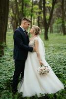 le jeune marié et le la mariée sont en marchant dans le forêt photo