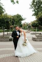 le marié en costume marron et la mariée en robe blanche photo