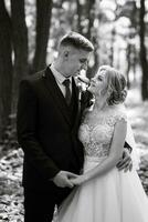 le jeune marié et le la mariée sont en marchant dans le forêt photo