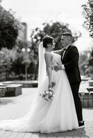 le marié en costume marron et la mariée en robe blanche photo