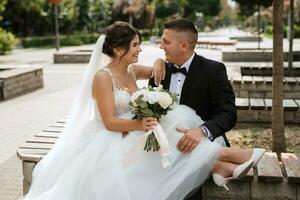 le marié en costume marron et la mariée en robe blanche photo