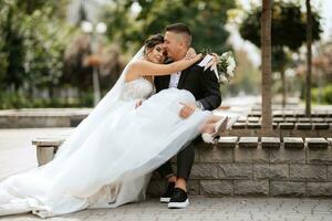 le marié en costume marron et la mariée en robe blanche photo