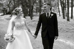 le jeune marié et le la mariée sont en marchant dans le forêt photo