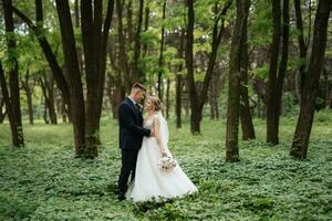 le jeune marié et le la mariée sont en marchant dans le forêt photo