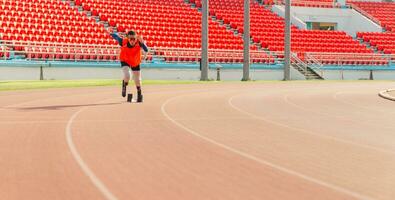 asiatique para-athlète coureur prothétique jambe sur le Piste seul à l'extérieur sur une stade Piste paralympique fonctionnement concept. photo