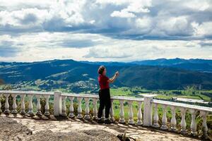 Jeune femme à une point de vue plus de le magnifique sopo vallée à le département de cundinamarca dans Colombie photo