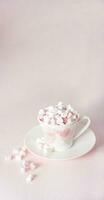 pastel pêche encore la vie avec mini guimauves dans porcelaine tasse avec rose cœurs, cadeau pour de la mère jour, Saint-Valentin journée photo