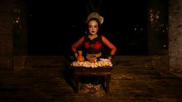 une femelle Danseur est assis gracieusement et commence sa rituel dans de face de magnifique offrandes photo