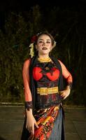 un indonésien Danseur dans une or et rouge costume des stands très gracieusement photo