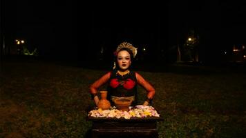 une femelle Danseur effectue une rituel cette crée une magique et mystique atmosphère dans de face de fleur offrandes photo