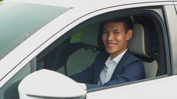 asiatique homme d'affaire conduite voiture avant achat Nouveau électrique véhicule. photo