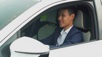 asiatique homme d'affaire conduite voiture avant achat Nouveau électrique véhicule. photo