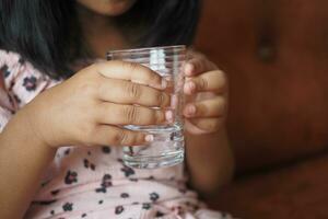 enfant main en portant une verre de l'eau photo