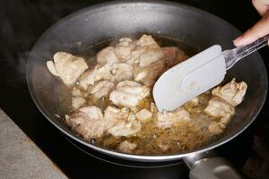 poulet pièces frit dans une cuisine la poêle photo