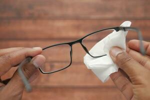 nettoyer les lunettes avec un mouchoir en papier en gros plan photo