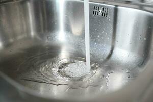 l'eau égouttage de robinet robinet à cuisine. fermer photo