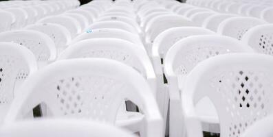 fermer et surgir blanc Plastique chaises mettre sur doublé dans Lignes pour élèves dans le l'obtention du diplôme cérémonie. photo